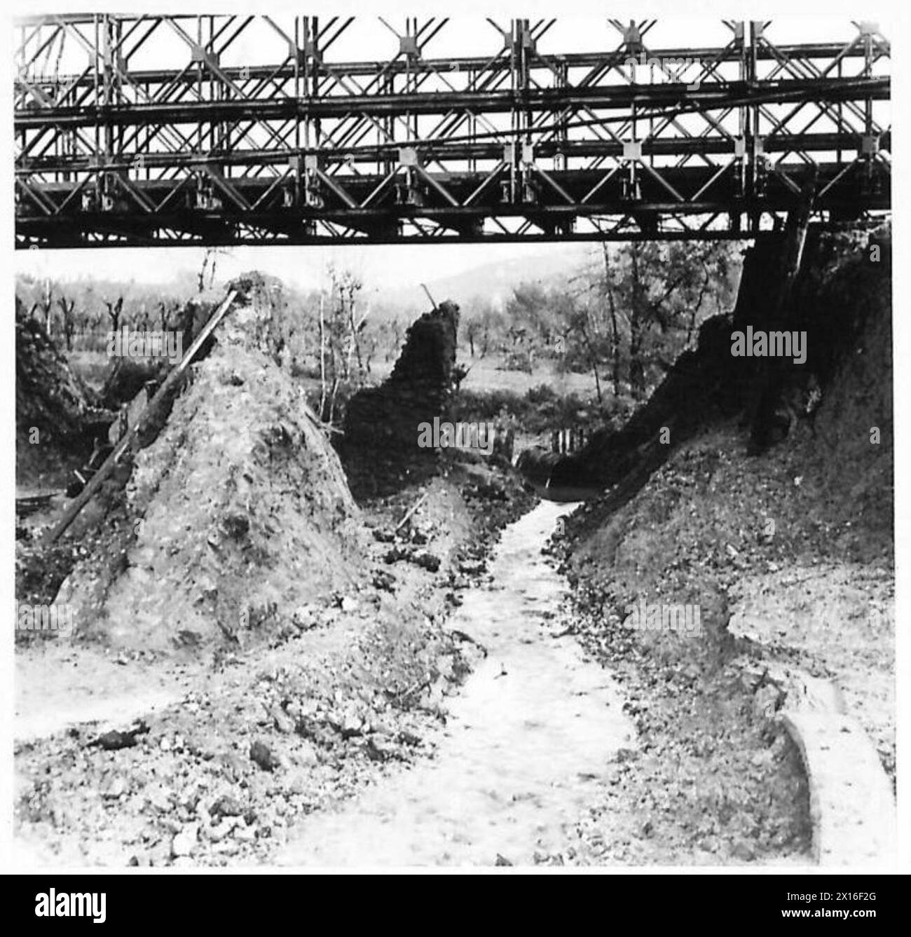 Le inondazioni autunnali in Italia causano danni alla strada; gli appaltatori scavano la terra vicino a un canale sotterraneo permanente, con 90 piedi. D.D. Bailey Bridge eretto il 3 novembre 1944 sotto la supervisione dell'esercito britannico. Foto Stock