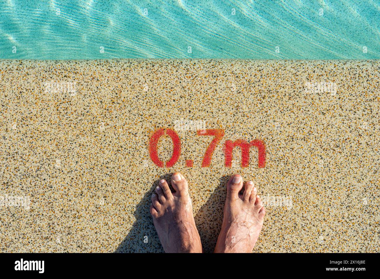 due piedi all'ingresso della piscina con un'indicazione di profondità di 0,7 metri. Foto Stock