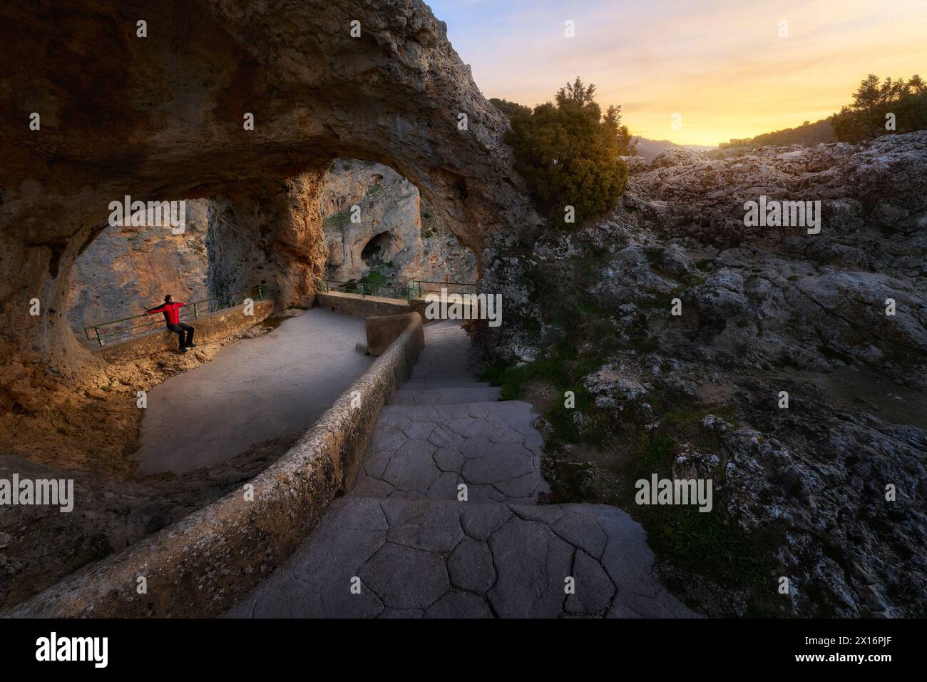 Un uomo che si gode la calma di una grotta vuota nella natura all'alba Foto Stock