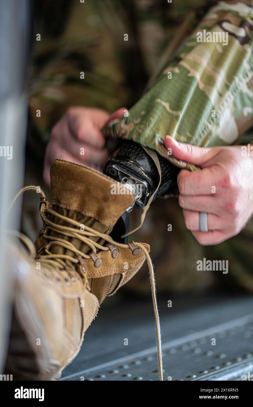 Una persona in uniforme militare sta regolando le cinghie di una gamba protesica. Concetto di resilienza e determinazione, in quanto la persona si sta adattando a una ne Foto Stock
