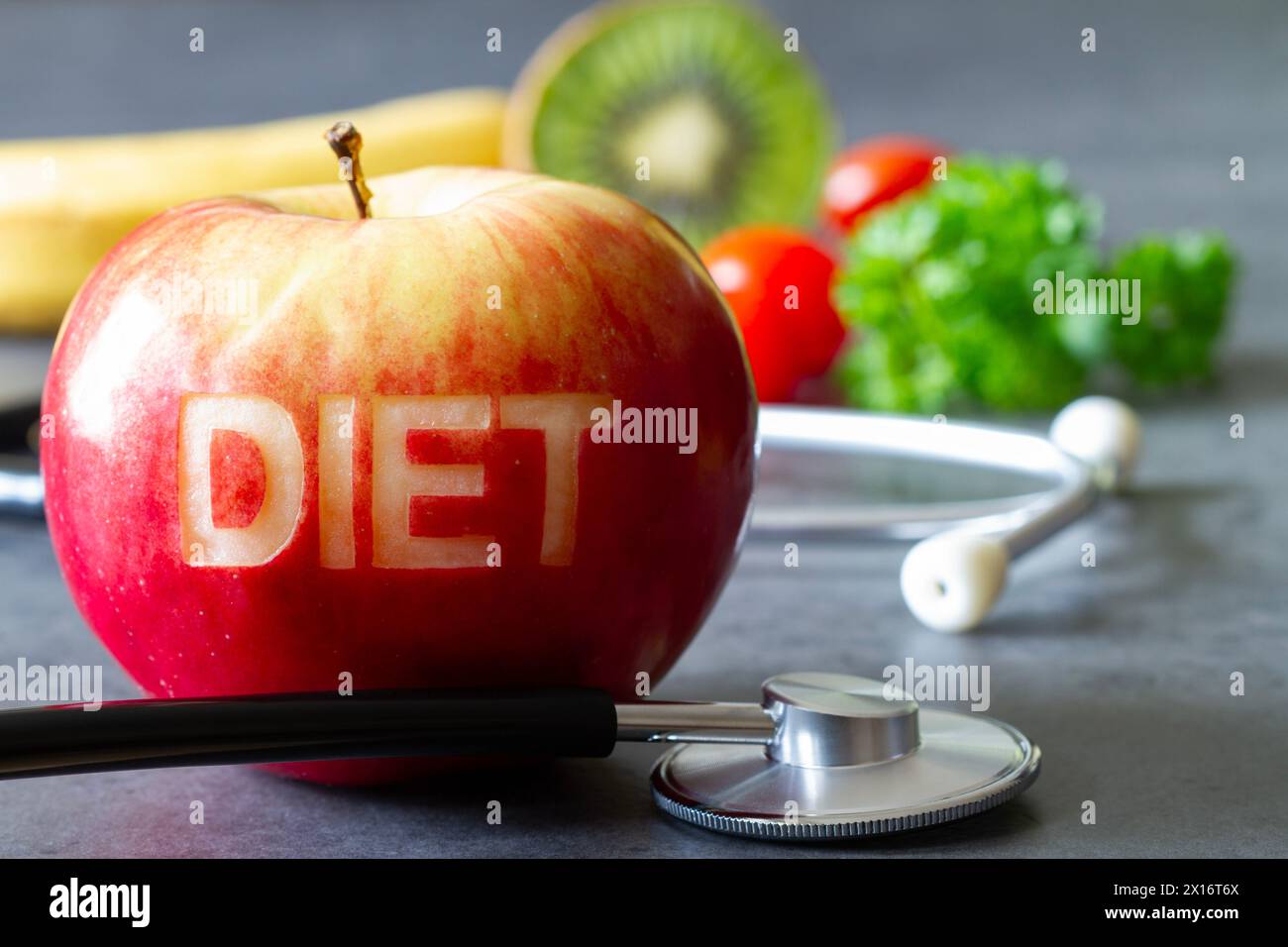 Mela rossa con dieta parola ritagliata, stetoscopio e frutta, dieta e concetto di stile di vita sano Foto Stock