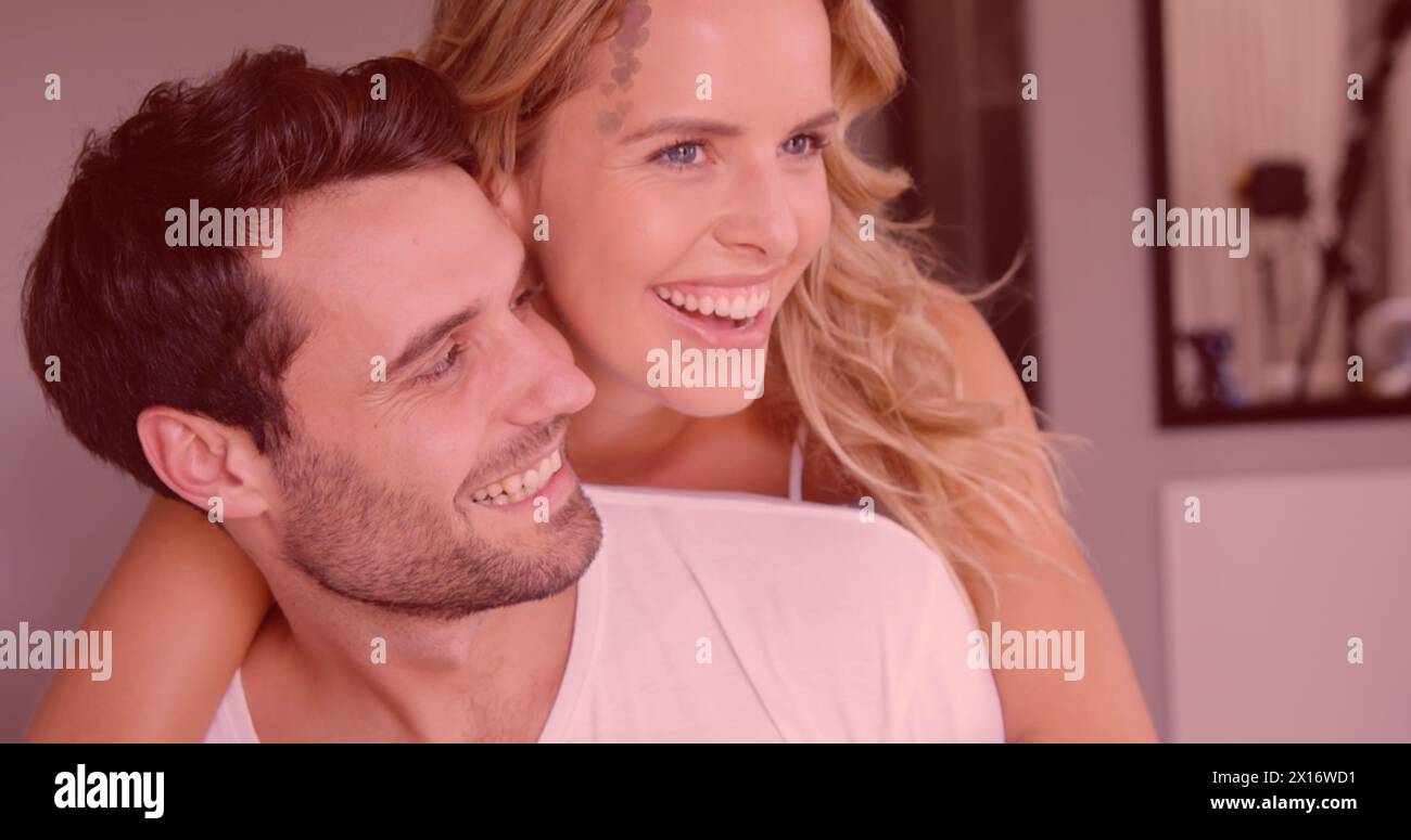 Immagine di cuori rossi su una coppia innamorata che abbraccia e sorride Foto Stock