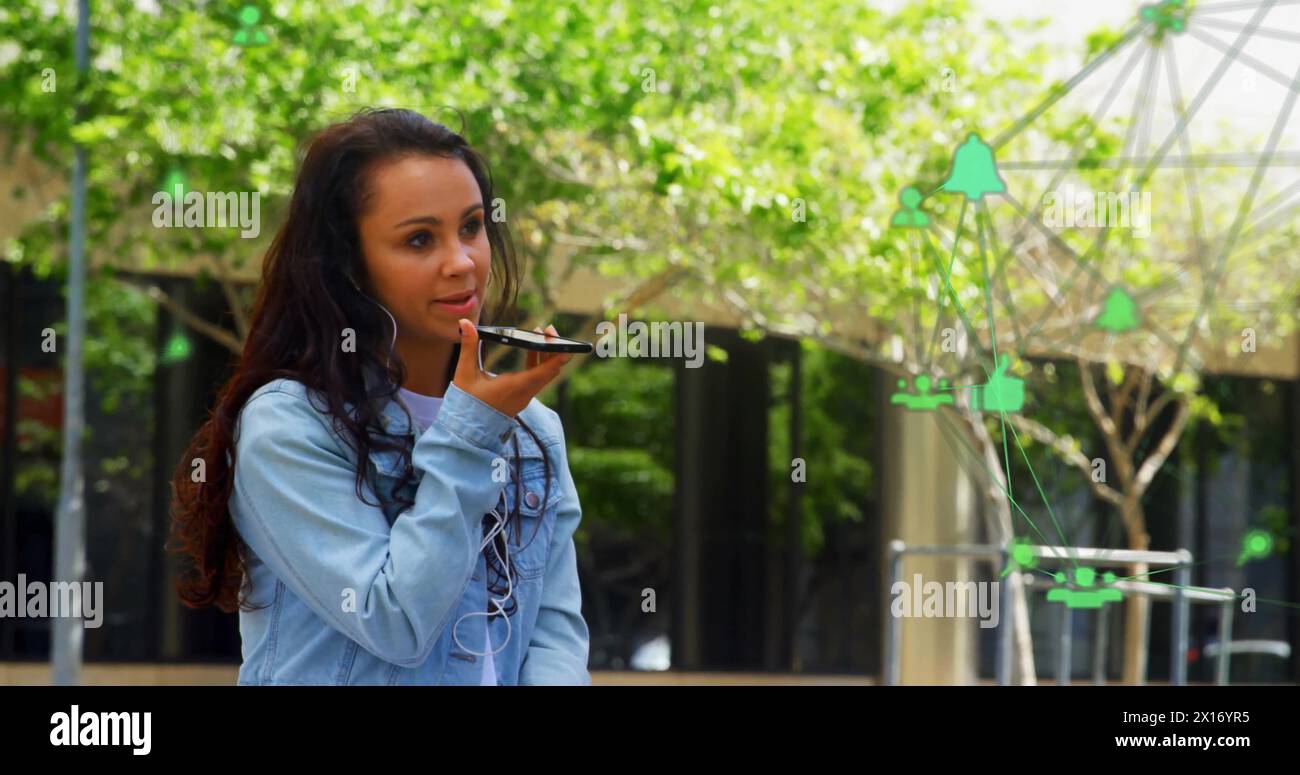 L'immagine di icone connesse si sovrappone a una donna birazziale che parla con l'altoparlante del cellulare Foto Stock