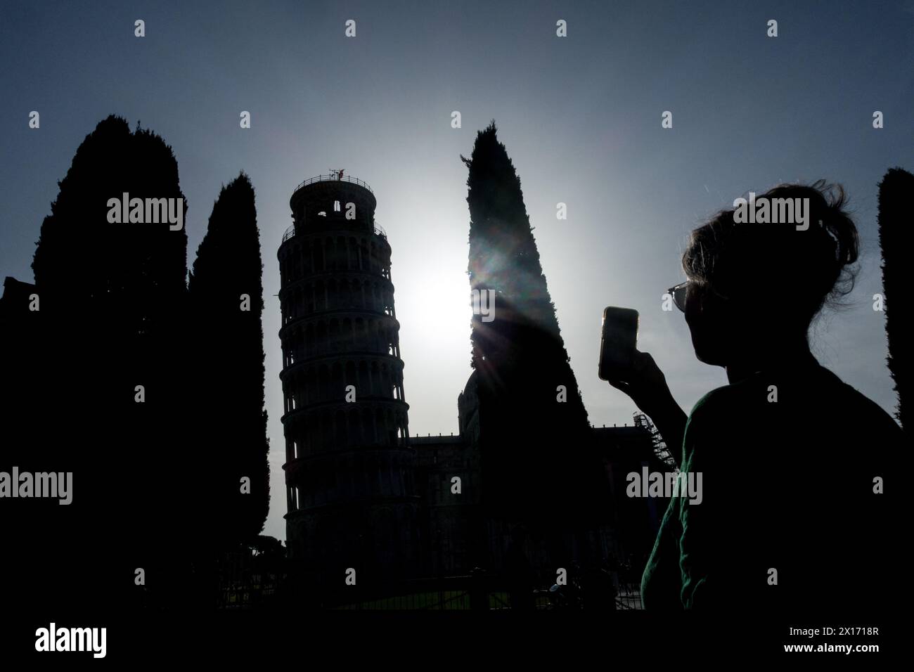 Silhouette di donna che scatta foto della Torre Pendente di Pisa con un telefono Foto Stock