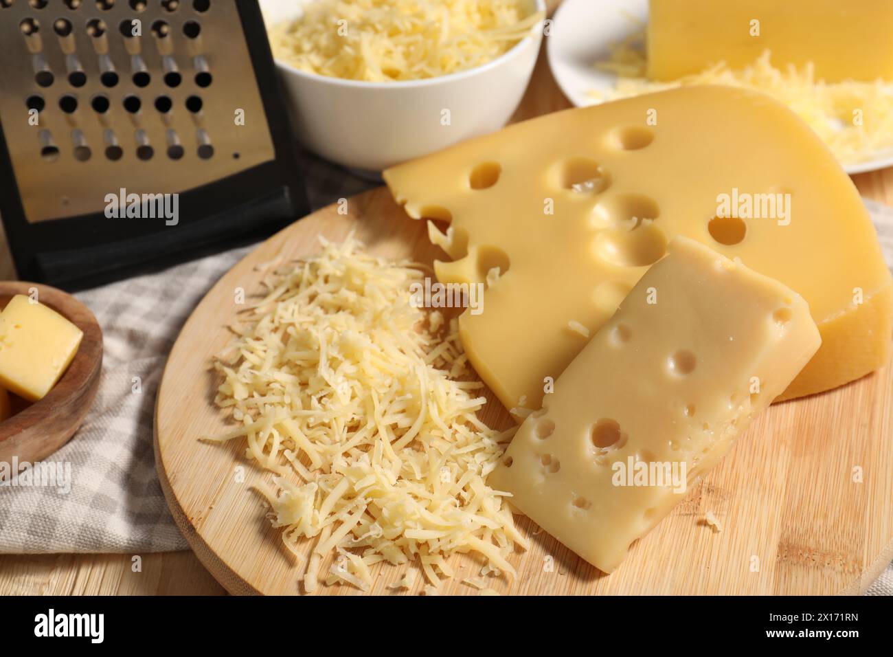 Grattugiato, tagliato il formaggio e grattugiato sul tavolo, primo piano Foto Stock