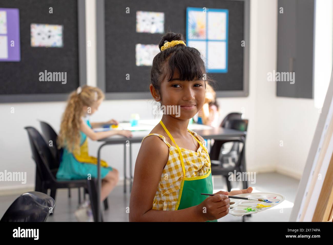 Nella classe d'arte scolastica, un gruppo eterogeneo di ragazze dipinge Foto Stock