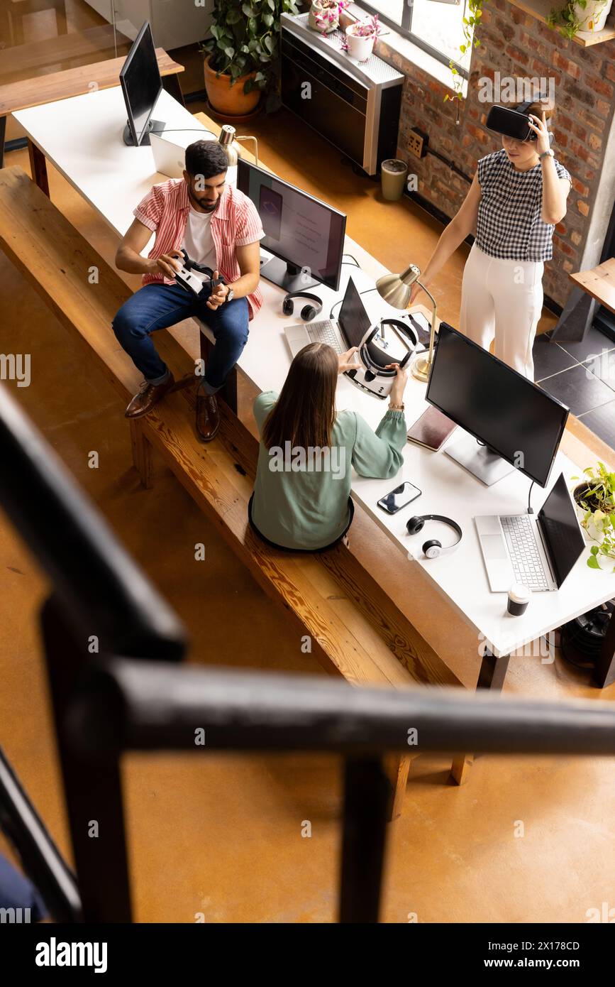 Un team diversificato di professionisti che lavorano al computer e discutono in un moderno ufficio aziendale Foto Stock