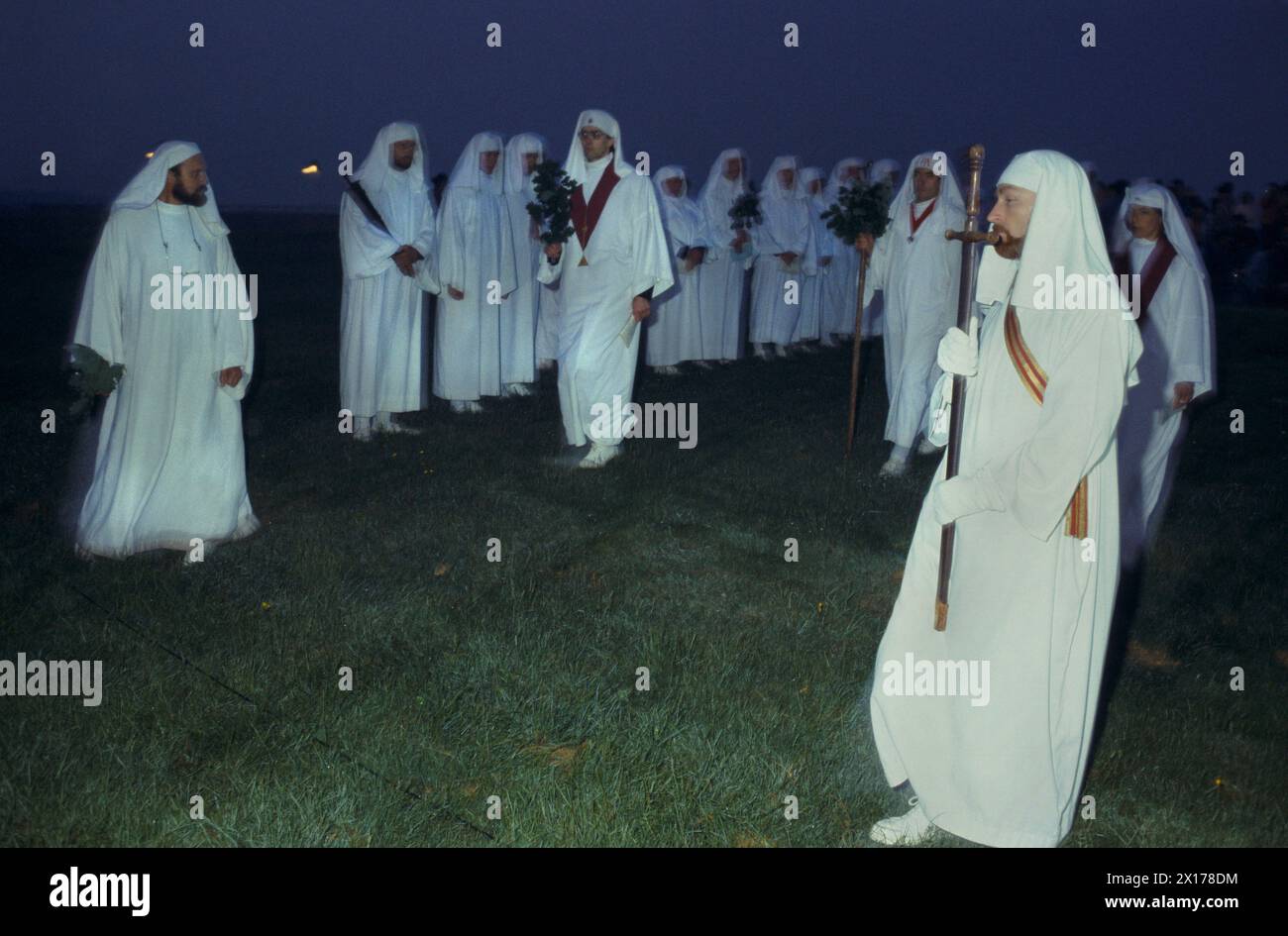 I druidi si riuniscono a Stonehenge, un antico monumento preistorico pagano per il solstizio d'estate. Si riuniscono la sera prima. Il culto pagano e i riti religiosi vengono eseguiti per tutta la notte fino all'alba e all'alba sopra le pietre del tallone. Salisbury Plain. Wiltshire, Inghilterra. Intorno agli anni '1975 1970 del Regno Unito HOMER SYKES Foto Stock
