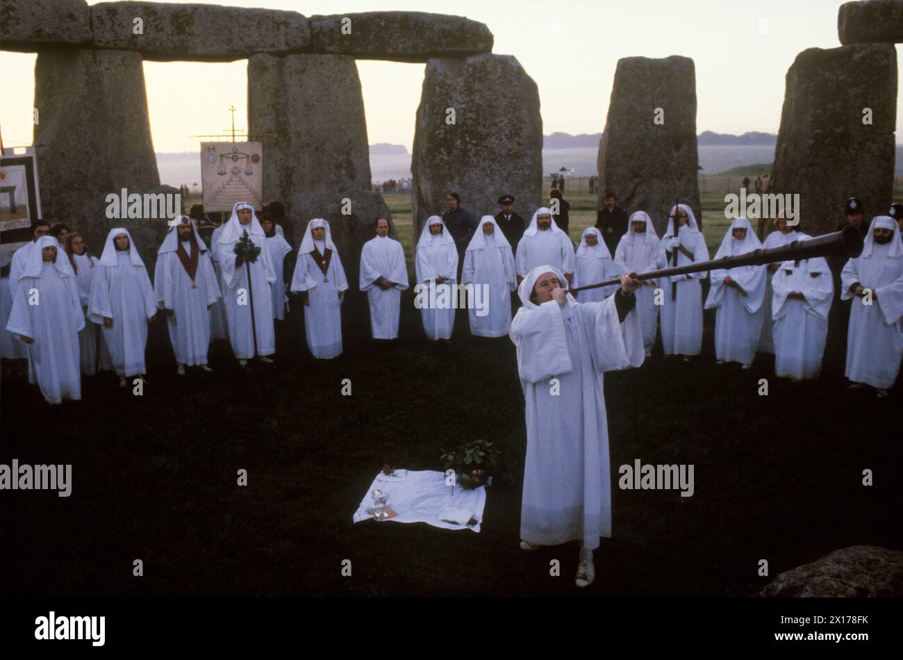 Druidi Stonehenge. Membri dell'ordine Druido alla celebrazione del solstizio d'estate. I Druidi festeggiano a Stonehenge Wiltshire il 21 giugno 1970 All'alba formano un cerchio all'interno del monumento preistorico henge ed eseguono riti e riti pagani tradizionali. Druido che soffia l'antico corno.Regno Unito Inghilterra. Circa 1975 HOMER SYKES Foto Stock