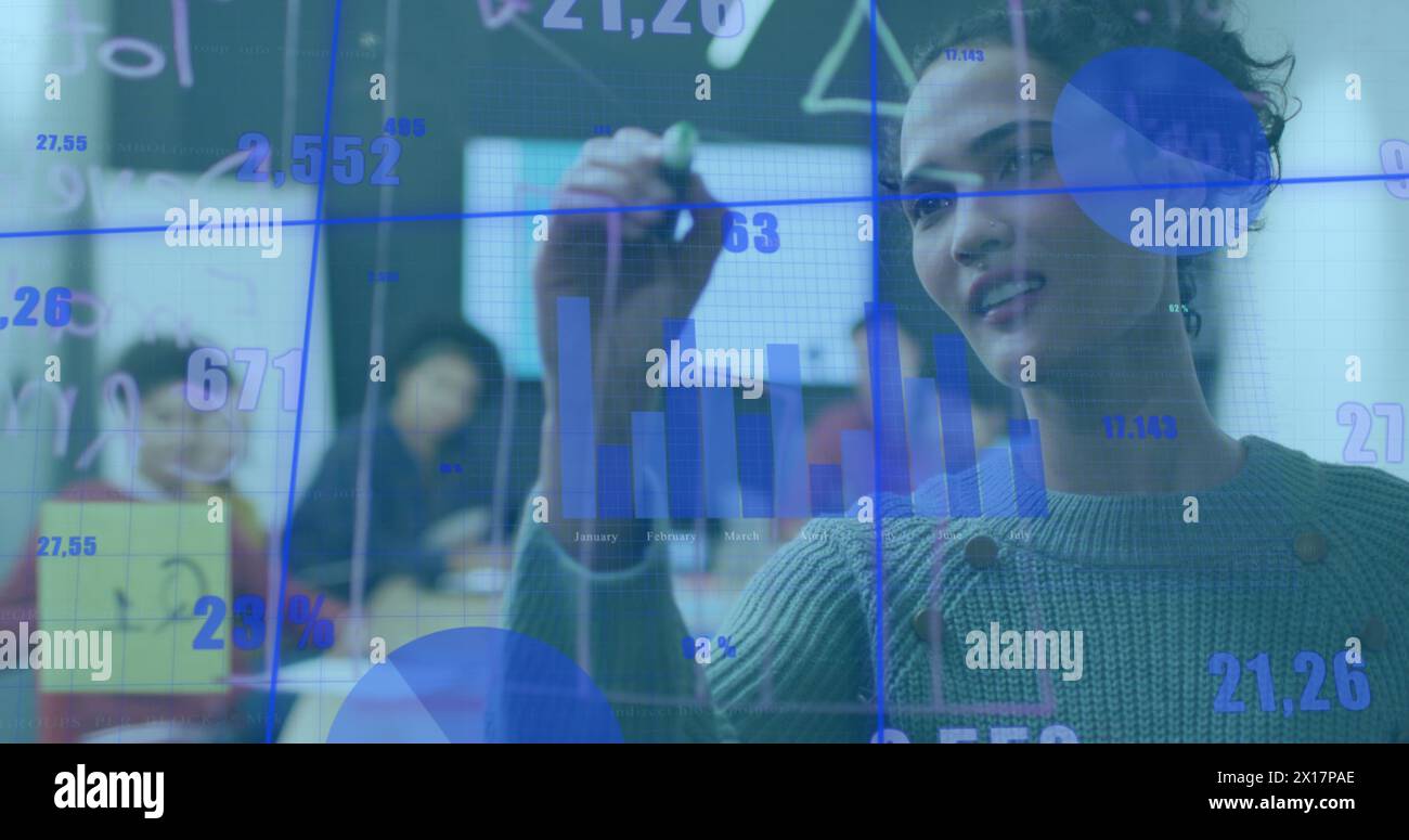 Immagine di griglia con grafici e numeri su una donna d'affari birazziale che scrive su una parete di vetro Foto Stock