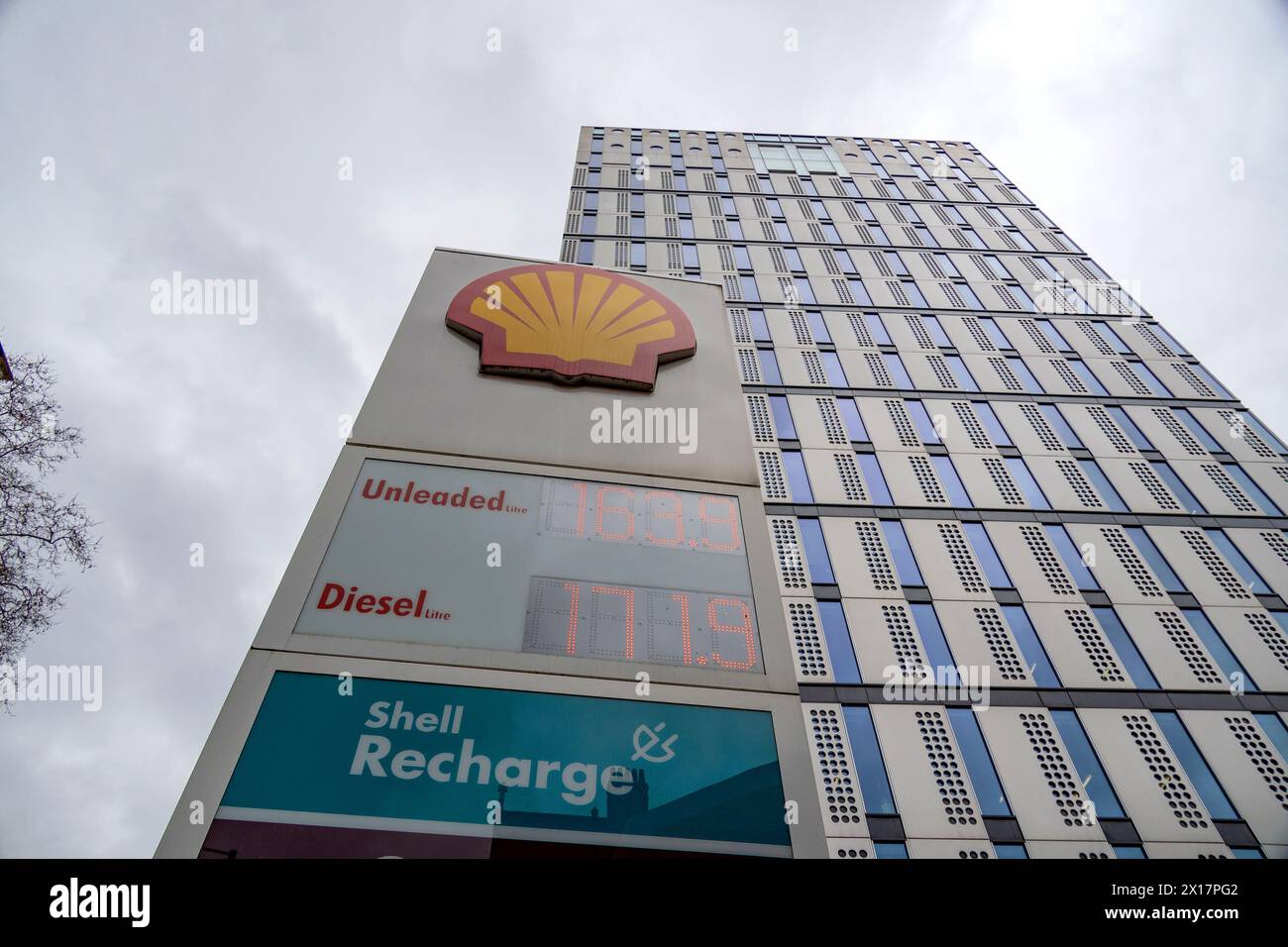 Prezzi moderni del carburante esposti presso una stazione Shell di Londra con sfondo alto Foto Stock