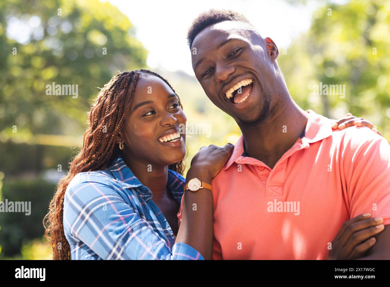 Le coppie afroamericane stanno abbracciando l'aria aperta, entrambe sorridenti, a casa Foto Stock