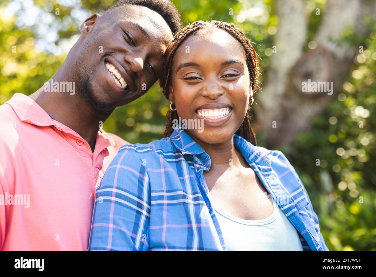 Coppia afroamericana sorridente all'aperto, godendosi il sole insieme a casa Foto Stock