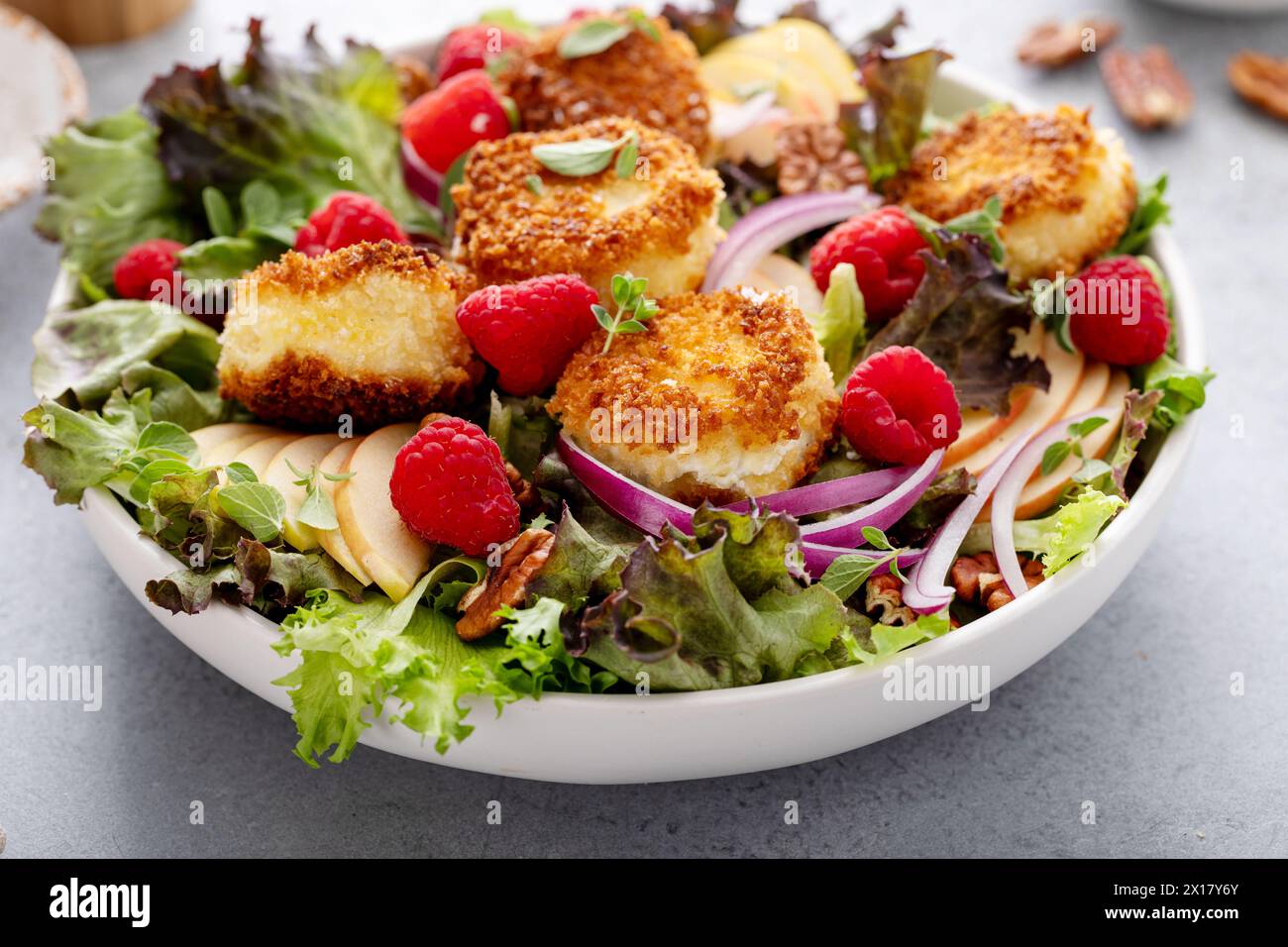 Insalata di formaggio di capra fritta con lamponi e cipolla rossa e insalata verde Foto Stock
