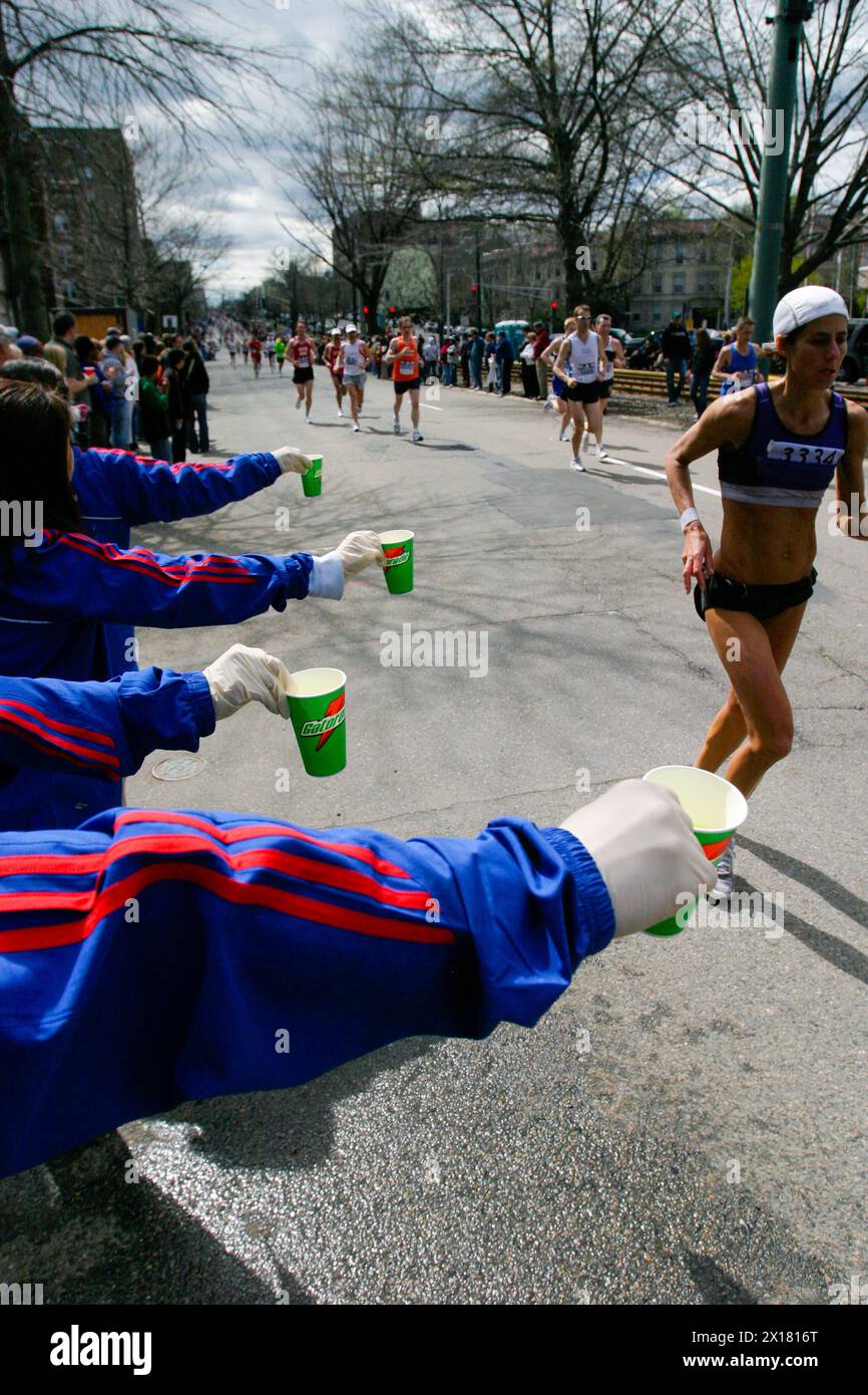 I volontari della maratona di Boston distribuiscono bevande ai corridori mentre si dirigono verso il traguardo a Boston, Massachusetts. Foto Stock