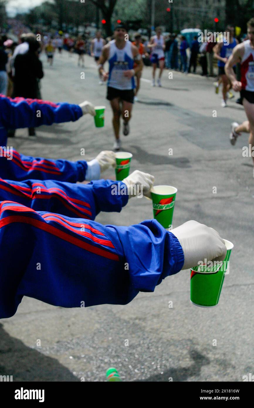 I volontari della maratona di Boston distribuiscono bevande ai corridori mentre si dirigono verso il traguardo a Boston, Massachusetts. Foto Stock