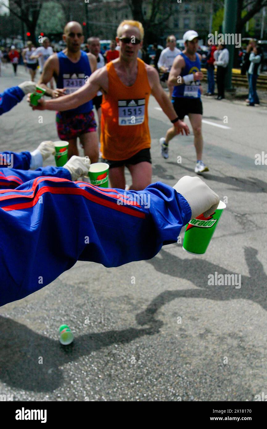 I volontari della maratona di Boston distribuiscono bevande ai corridori mentre si dirigono verso il traguardo a Boston, Massachusetts. Foto Stock