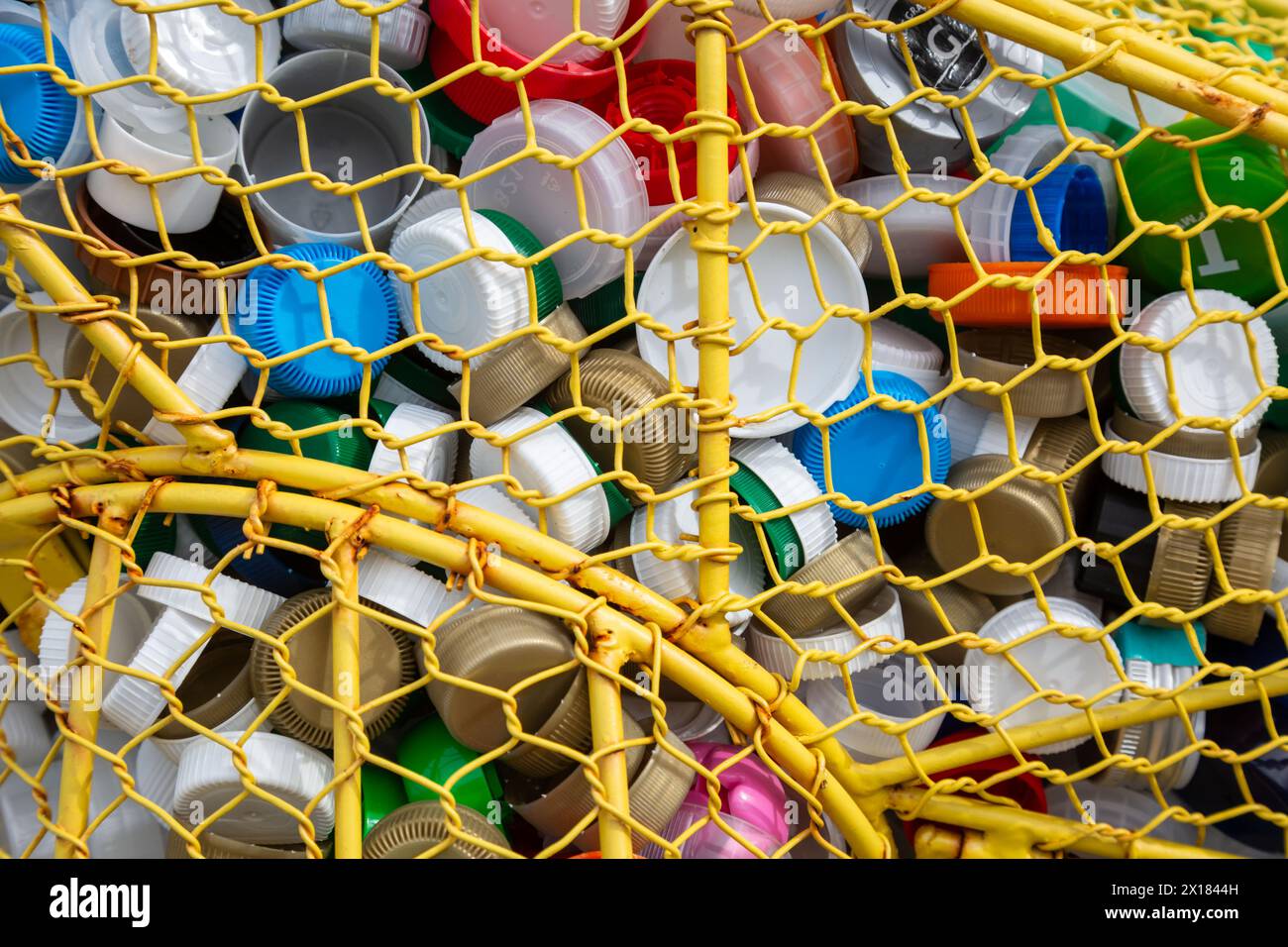 Una raccolta di tappi per bottiglie in plastica per il riciclaggio. Foto Stock