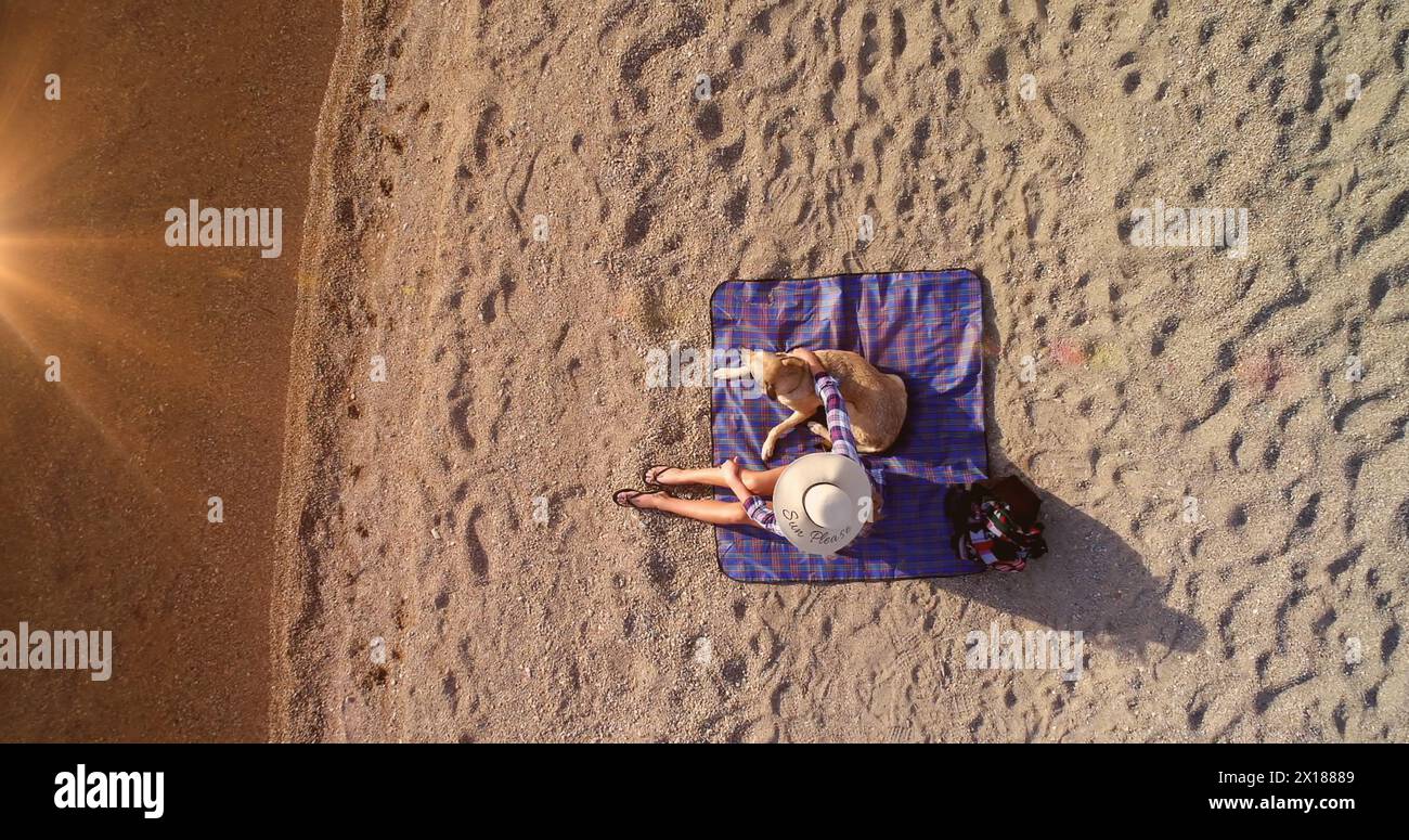 Immagine di macchie di luce sulla donna caucasica con il cane in spiaggia Foto Stock