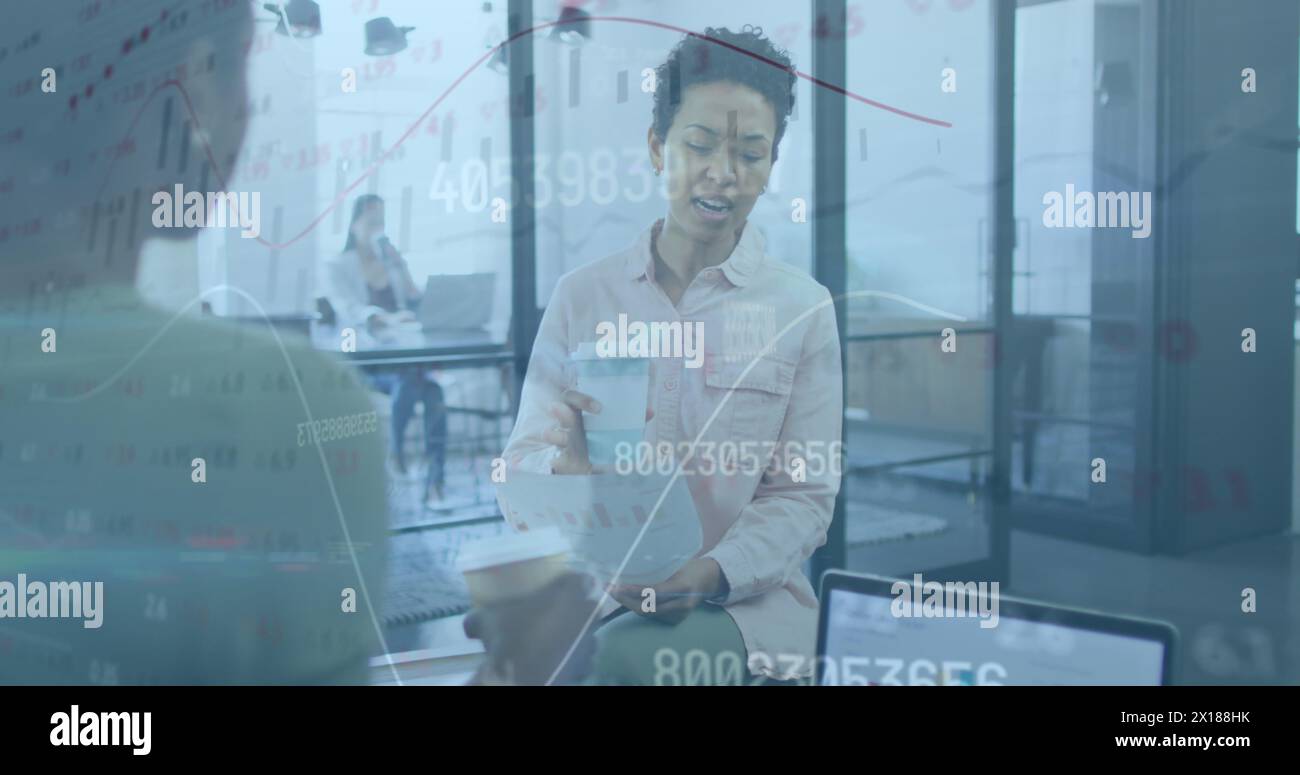 Due donne d'affari lavorano insieme in un ufficio, si godono un caffè e chiacchierano una donna lo è Foto Stock