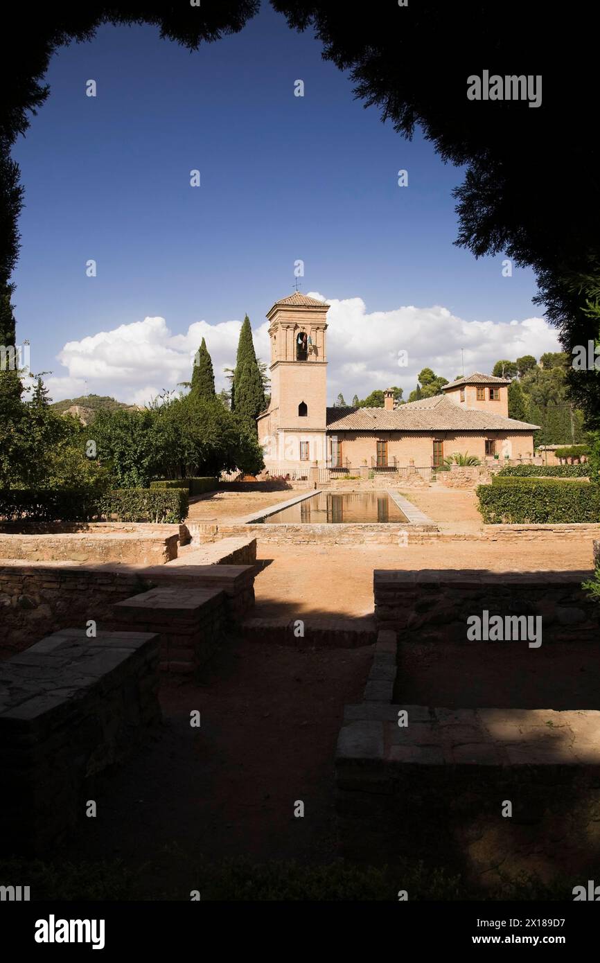 Giardino ornamentale con bacino d'acqua a specchio e una torre sul terreno del palazzo dell'Alhambra, Granada, Spagna Foto Stock