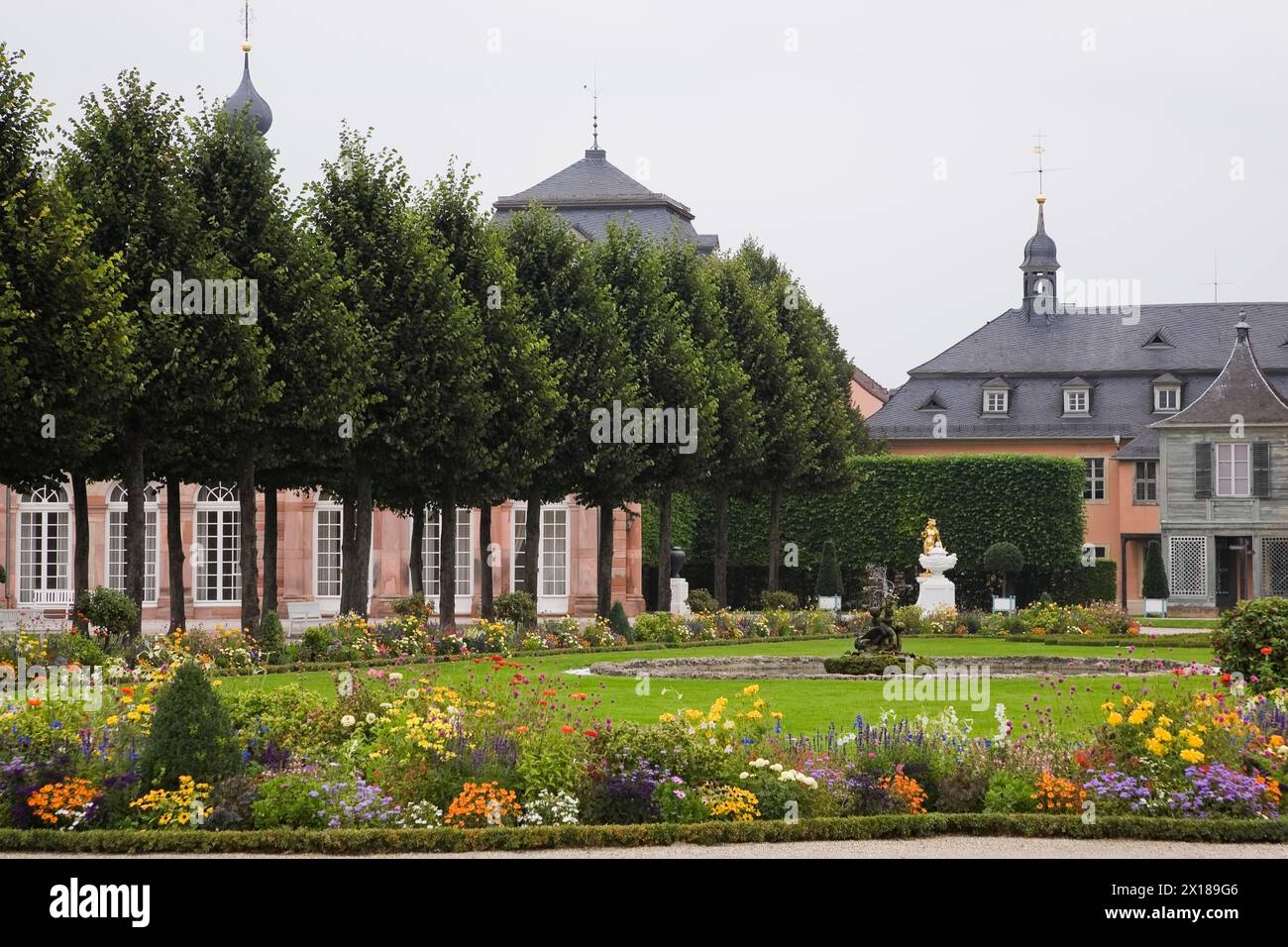 Bordi floreali misti, alberi topiari e fontana d'acqua nel giardino del palazzo Schwetzingen a fine estate, Schwetzingen, Germania Foto Stock