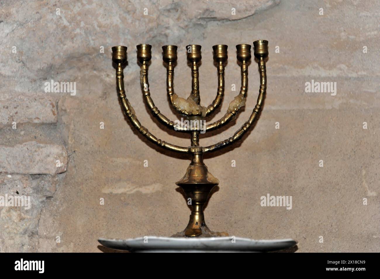 Cordova, Una menorah color oro di fronte a un vecchio muro di pietra, simbolo dell'Ebraismo, Cordova, Andalusia, Spagna Foto Stock