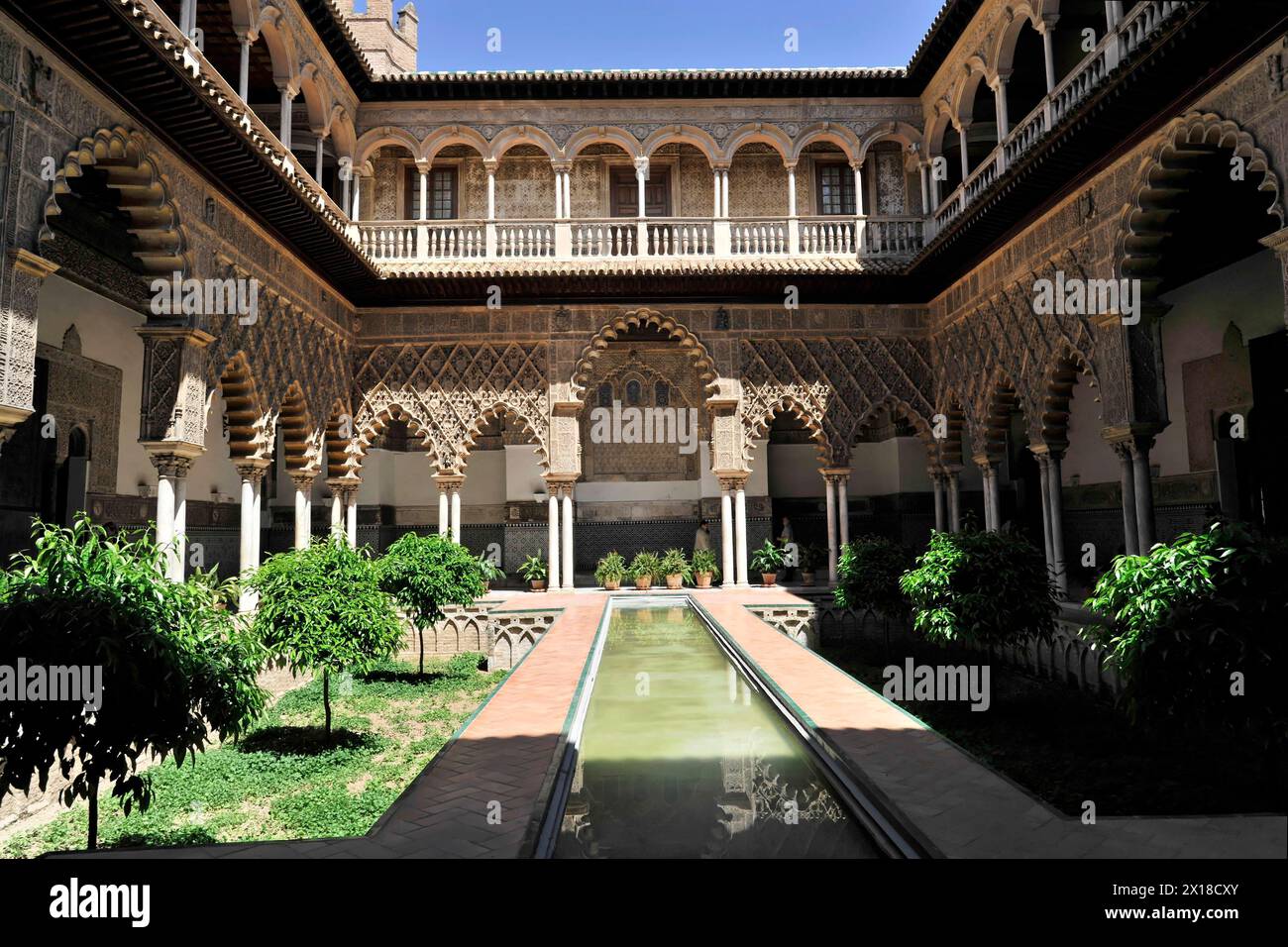 Siviglia, il Palazzo reale Real Alcazar, sito patrimonio dell'umanità dell'UNESCO, a Siviglia, i portici circondano un tranquillo cortile interno con un lungo canale d'acqua Foto Stock