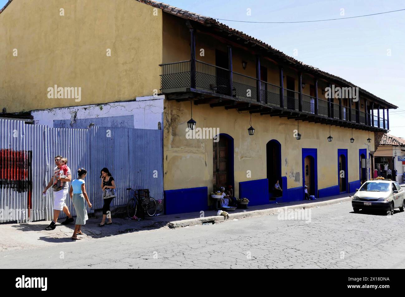 Leon, Nicaragua, persone che camminano lungo edifici storici in una strada acciottolata, America centrale, America centrale - Foto Stock