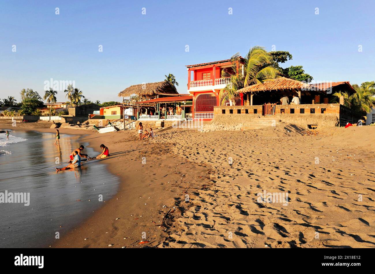 Spiaggia vicino a Poneloya, Las Penitas, Leon, Nicaragua, vista spiaggia con un suggestivo edificio rosso e palme sullo sfondo, America centrale, centrale Foto Stock