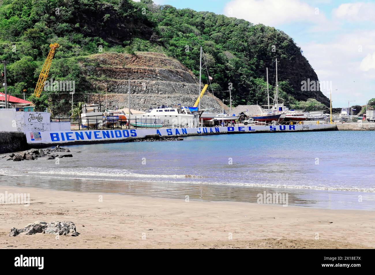 San Juan del Sur, Nicaragua, spiaggia sabbiosa con un grande cartello di benvenuto e barche sullo sfondo, America centrale, America centrale Foto Stock
