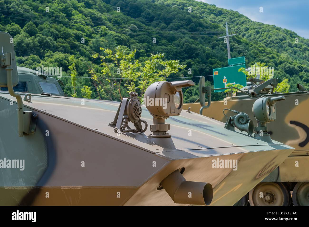 Vista frontale ravvicinata dei fari del veicolo militare in mostra nel parco pubblico di Nonsan, Corea del Sud Foto Stock