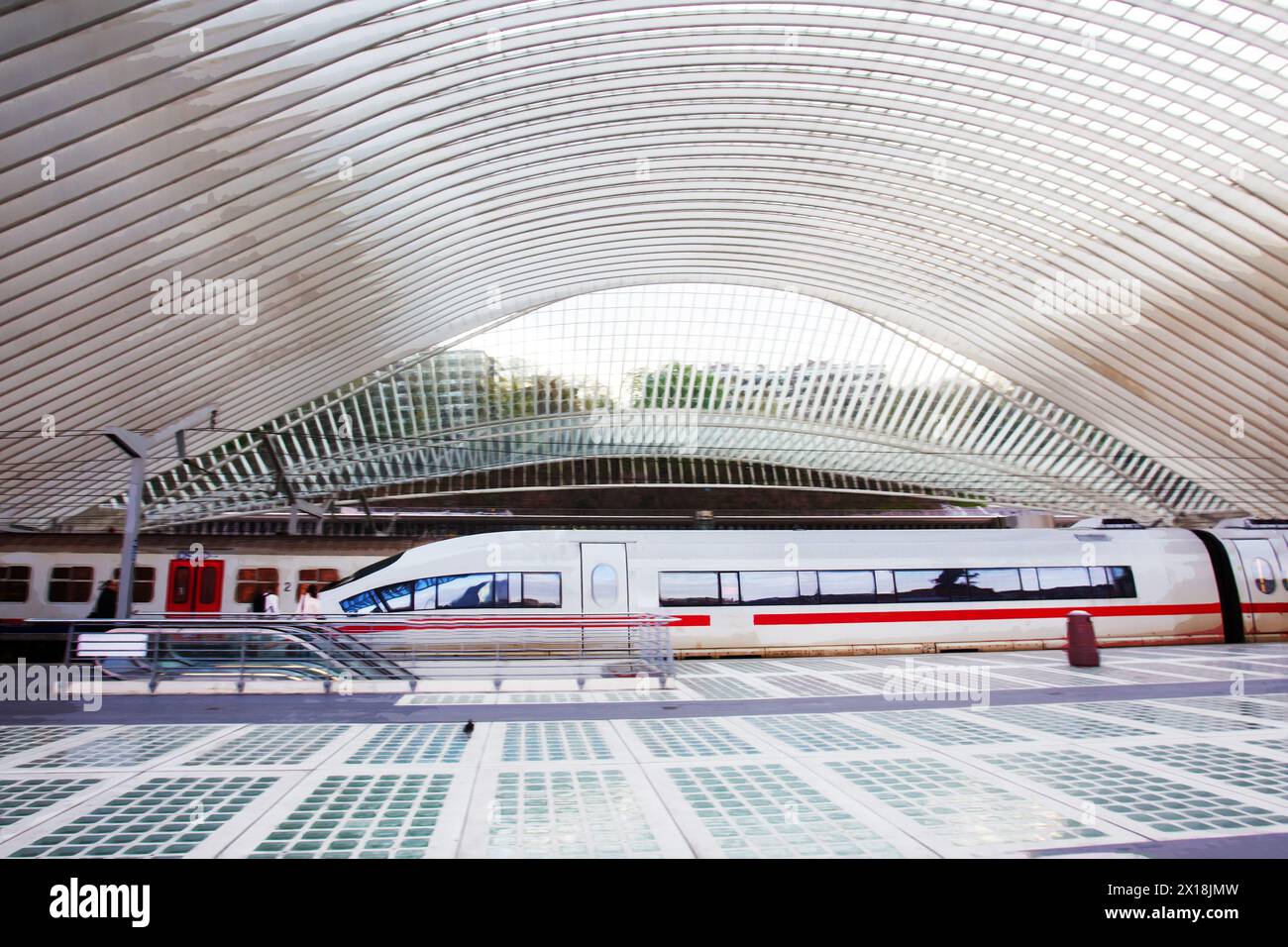 19-04-2016 Liegi BELGIUM Speed train sulla futuristica stazione ferroviaria di Liegi. Persone in lontananza. Foto Stock