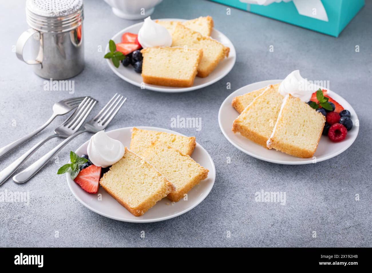 Tradizionale torta alla vaniglia a fette e servita con panna montata e frutti di bosco freschi Foto Stock