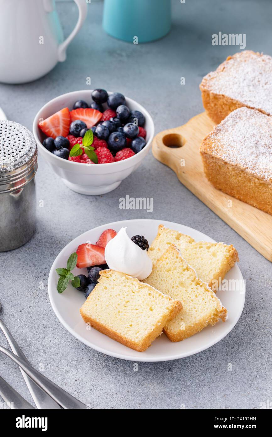 Tradizionale torta alla vaniglia a fette e servita con panna montata e frutti di bosco freschi Foto Stock