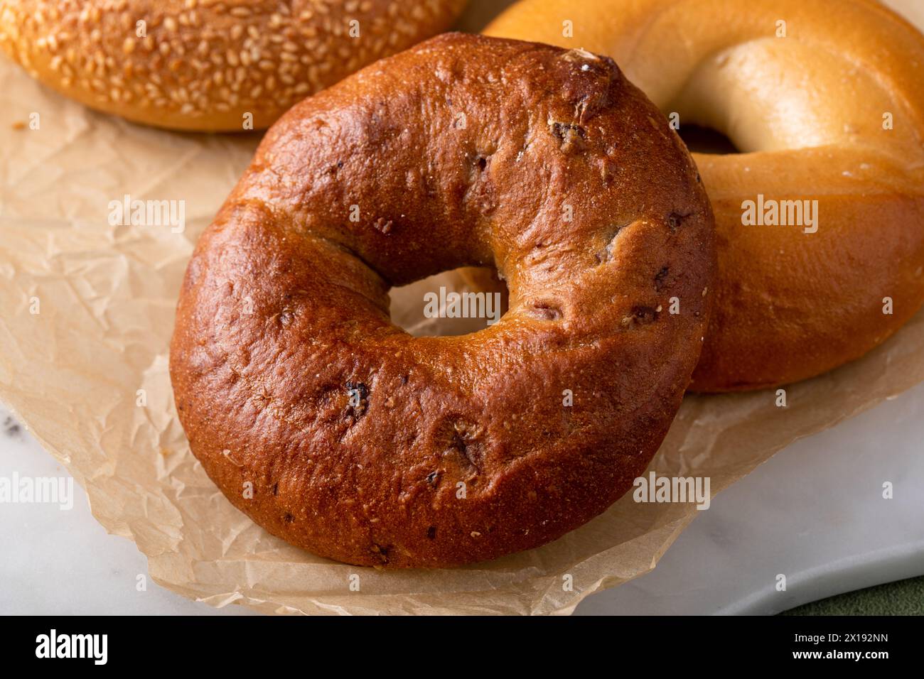 Bagel appena sfornati pronti per la colazione, sesamo, cannella e bagel semplici Foto Stock