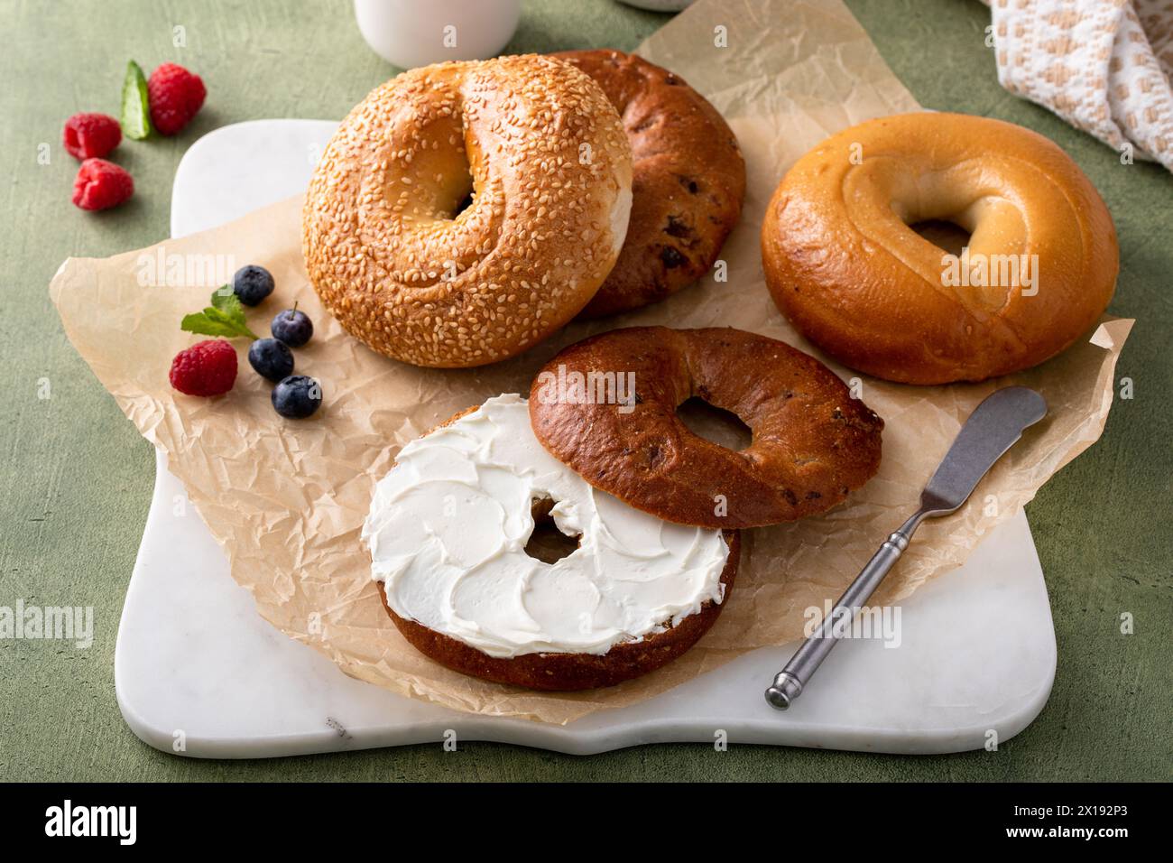 Bagel appena sfornati pronti per la colazione, sesamo, cannella e bagel semplici Foto Stock