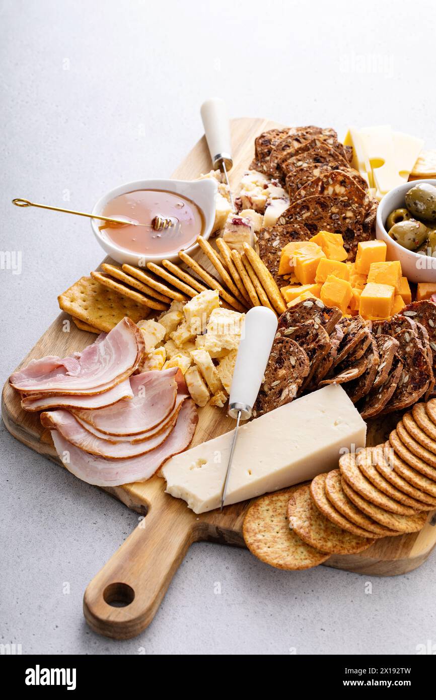 Tagliere di salumi o formaggi e snack con cracker, miele e olive Foto Stock