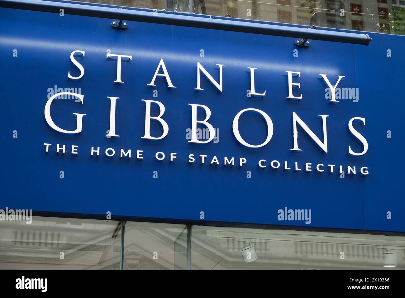 Londra, Regno Unito - 25 marzo 2024 - insegna del negozio blu e bianco per Stanley Gibbons, la casa della collezione di francobolli Foto Stock