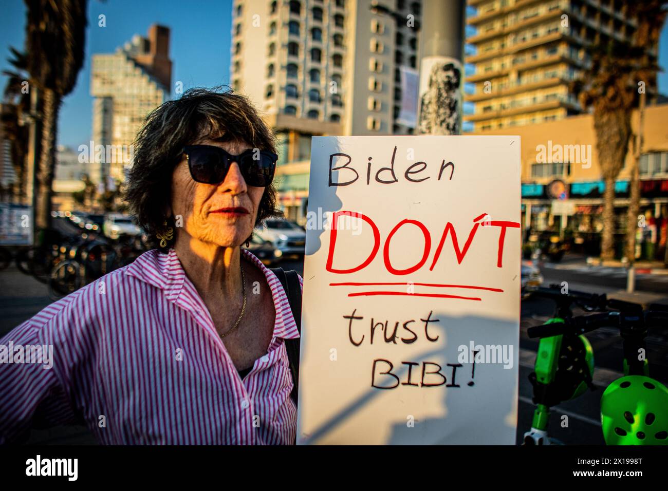 Tel Aviv, Israele. 15 aprile 2024. Un manifestante ha un cartello che chiede al presidente degli Stati Uniti Joe Biden di non fidarsi del primo ministro israeliano Benjamin Netanyahu durante una manifestazione. Israele ha promesso di "determinare un prezzo” dall'Iran dopo un attacco senza precedenti su larga scala con drone e missili nel fine settimana che ha intensificato le tensioni regionali innescate dalla guerra a Gaza. Credito: SOPA Images Limited/Alamy Live News Foto Stock