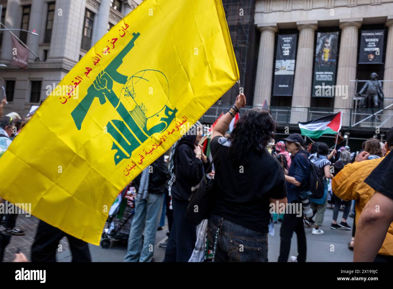 New York, Stati Uniti. 15 aprile 2024. Una donna porta una bandiera Hezbollah durante la manifestazione. Il gruppo di attivisti pro-palestinesi durante la nostra vita ha organizzato una protesta all'11 di Wall Street. La protesta in seguito tentò di marciare attraverso il ponte di Brooklyn come parte di un tentativo multi-città/multi-paese di creare un "blocco economico" in solidarietà con la Palestina. Sono stati fatti diversi arresti. (Foto di Syndi Pilar/SOPA Image/Sipa USA) credito: SIPA USA/Alamy Live News Foto Stock