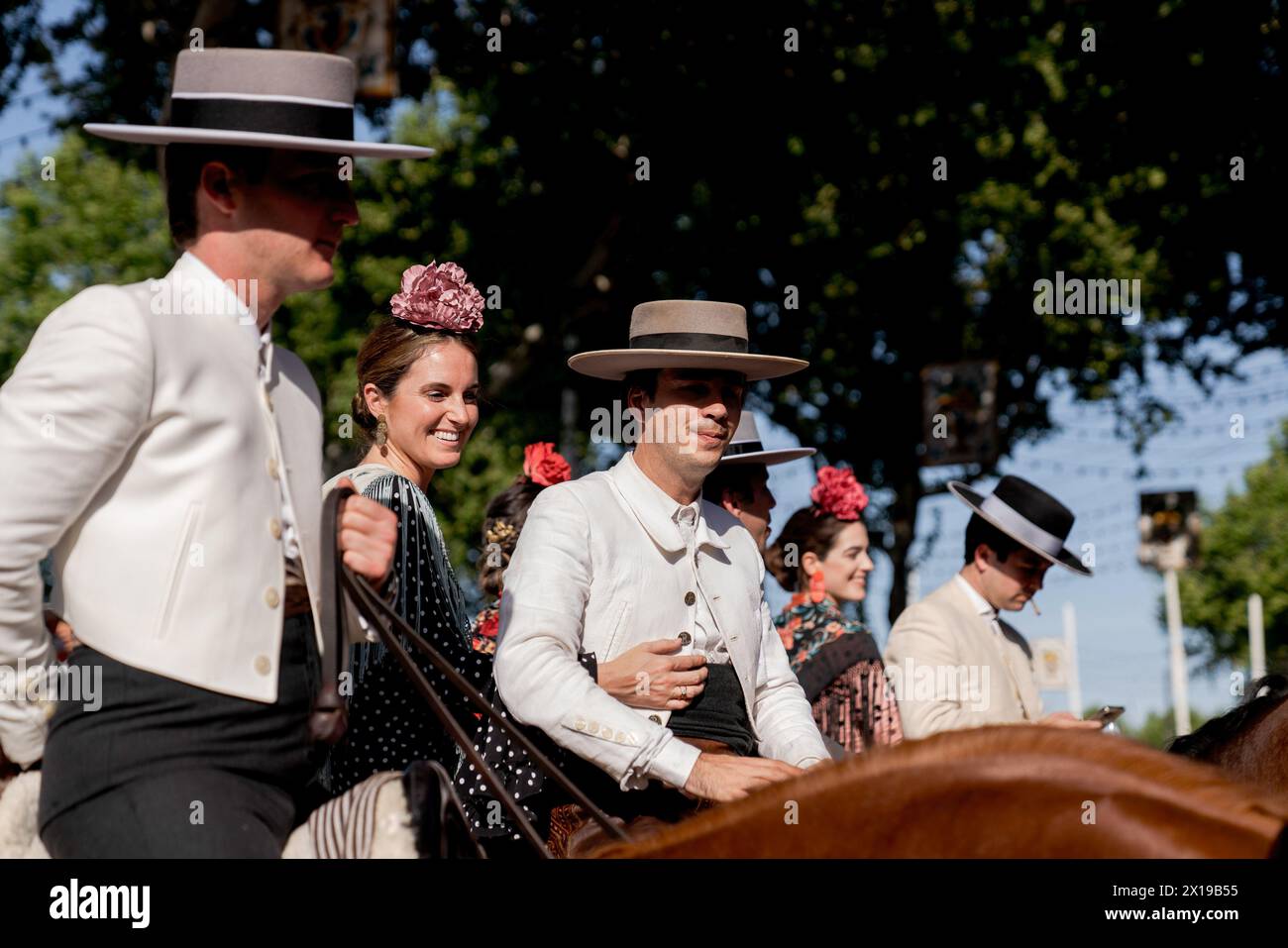 Durante la fiera si vedono diverse coppie vestite con i loro costumi tradizionali a cavallo. La Fiera di aprile è uno dei festival più internazionali e popolari di Siviglia. Creata nel 1847 come fiera del bestiame, nel tempo l'aspetto festivo dell'evento finì per assumere la parte commerciale, fino a diventare un evento essenziale per i sivigliani. Per una settimana, più di mille stand installati nella zona fieristica sono diventati la seconda casa degli abitanti di questa città, uno spazio dove condividere e divertirsi in compagnia fino alle prime ore del mattino. Finché il festival dura, gente dre Foto Stock