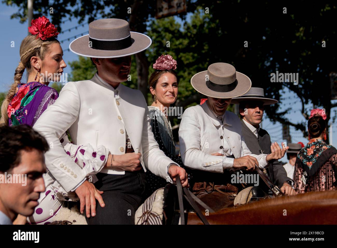 Durante la fiera si vedono diverse coppie vestite con i loro costumi tradizionali a cavallo. La Fiera di aprile è uno dei festival più internazionali e popolari di Siviglia. Creata nel 1847 come fiera del bestiame, nel tempo l'aspetto festivo dell'evento finì per assumere la parte commerciale, fino a diventare un evento essenziale per i sivigliani. Per una settimana, più di mille stand installati nella zona fieristica sono diventati la seconda casa degli abitanti di questa città, uno spazio dove condividere e divertirsi in compagnia fino alle prime ore del mattino. Finché il festival dura, gente dre Foto Stock