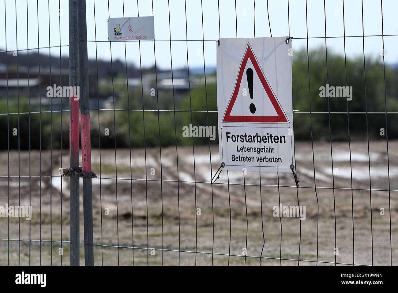 An einem Absperrzaun an einem Industriegebiet nahe des Flughafens Zweibrücken hängt ein rot-weißes Schild, auf dem vor Forstarbeiten und möglicher Lebensgefahr gewarnt wird. Warnschild Forstarbeiten **** Un cartello rosso e bianco è appeso su una recinzione di barriera in una zona industriale vicino all'aeroporto di Zweibrücken per avvisare di lavori forestali e di possibili pericoli per la vita cartello di avvertimento per lavori forestali Foto Stock