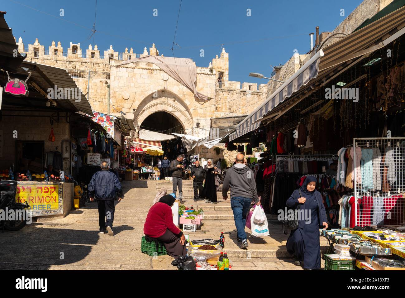Gerusalemme, Israele - 24 febbraio 2023: Le persone fanno shopping e passeggiano nel quartiere musulmano di fronte alla porta di Damsco nella città vecchia di Gerusalemme. Foto Stock