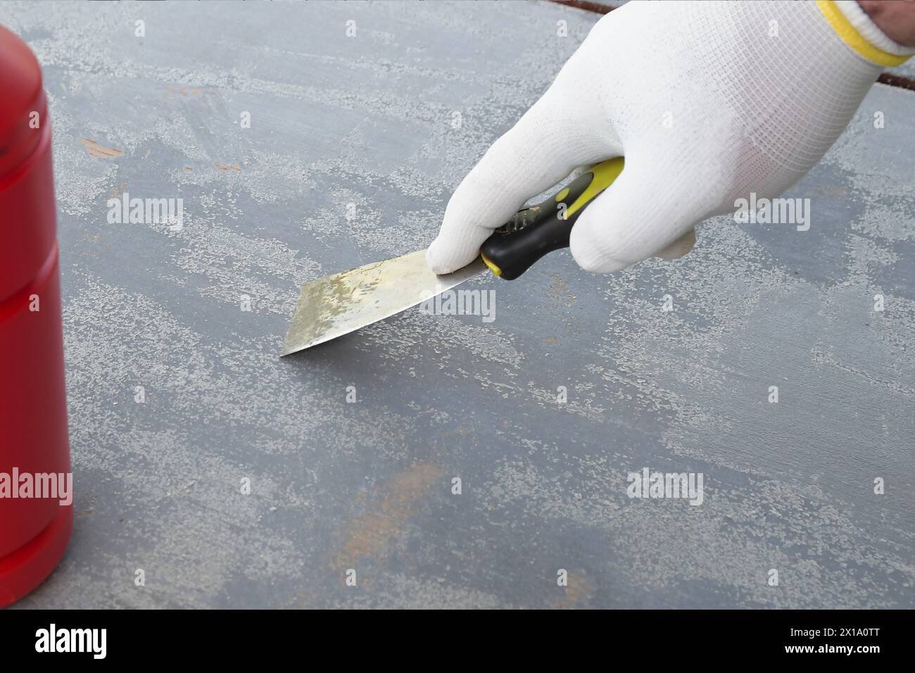 Rimuovere la vernice vecchia da una superficie di legno con una spatola Foto Stock