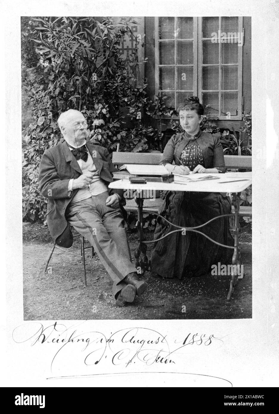 Felder, Cajetan baron von, in età più avanzata insieme alla sua segretaria Rosa Rittner durante la dettatura al tavolo del giardino di fronte alla parete esterna vegetata con finestra., 01.08.1888 - 18880801 PD0001 - Rechteinfo: Rights Managed (RM) Foto Stock