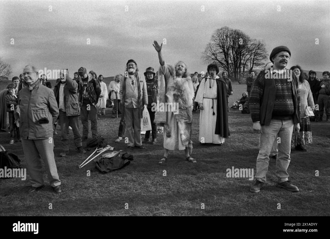 Membri hippie New age dell'ordine Druido britannico, cantando incantesimi a Nord, Sud, Est e Ovest. Philip Shallcrass, spesso conosciuto con il suo nome Druido, Greywolf, è capo dell'ordine Druido britannico. Egli saluta lo Spirito del Nord, lo Spirito della Terra, vi ringraziamo per i doni che ci avete portato e salutate e salutiamo. Avebury, Wiltshire, 1996. Avebury è un monumento neolitico all'henge contenente tre cerchi di pietra Inghilterra Regno Unito, HOMER SYKES degli anni '1990 Foto Stock