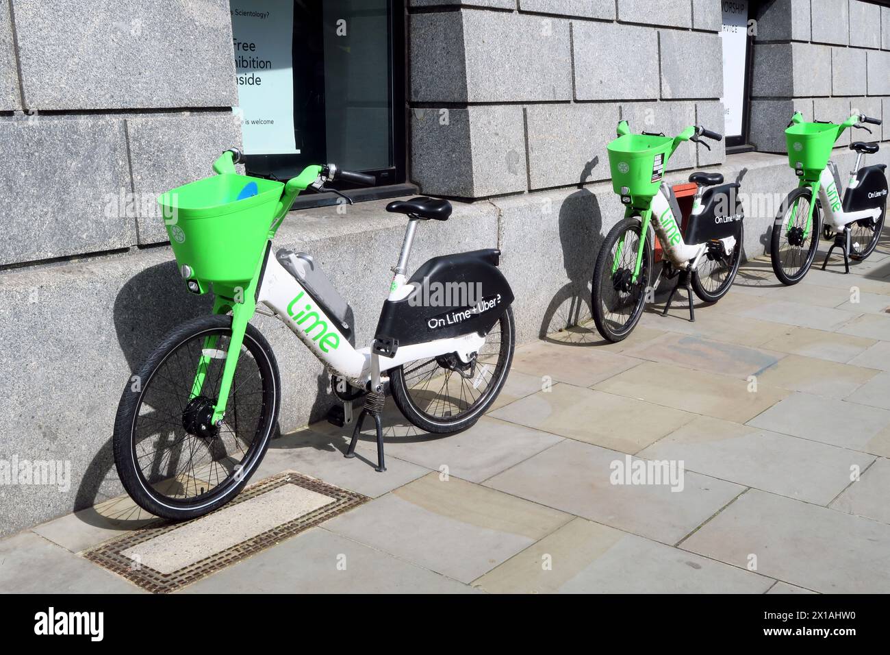 Tre biciclette Lime a noleggio presso il quartier generale della Chiesa di Scientology in Queen Victoria Street, nella City di Londra Foto Stock
