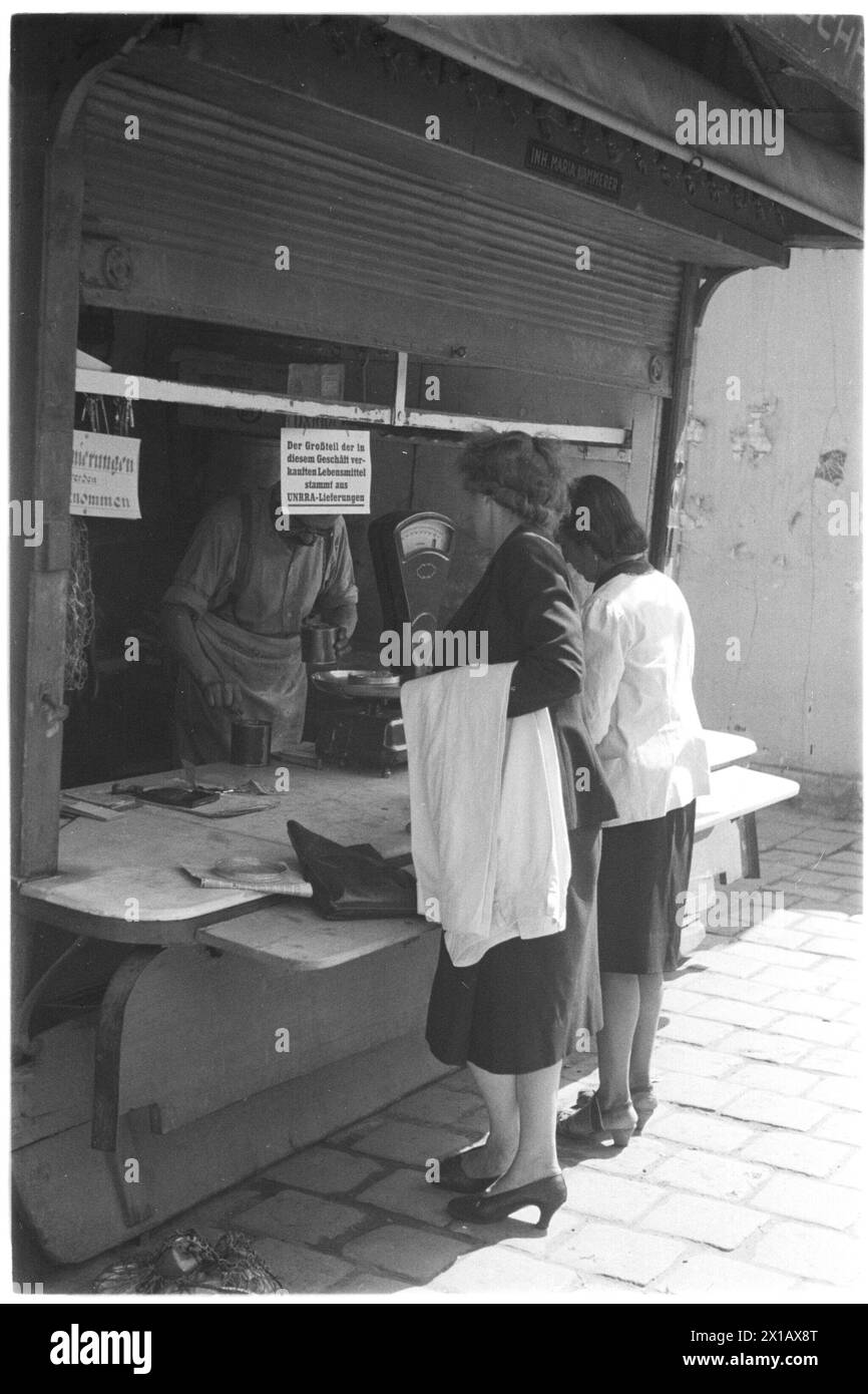 UNRRA-Stand al Rochusmarkt (piazza), due donne allo stallo, sopra un cartello "Der Grossteil der in diesem Geschaeft verkauften Lebensmittel stammt aus UNRRA-Lieferungen", 1946 - 19460101 PD1733 - Rechteinfo: Rights Managed (RM) Foto Stock